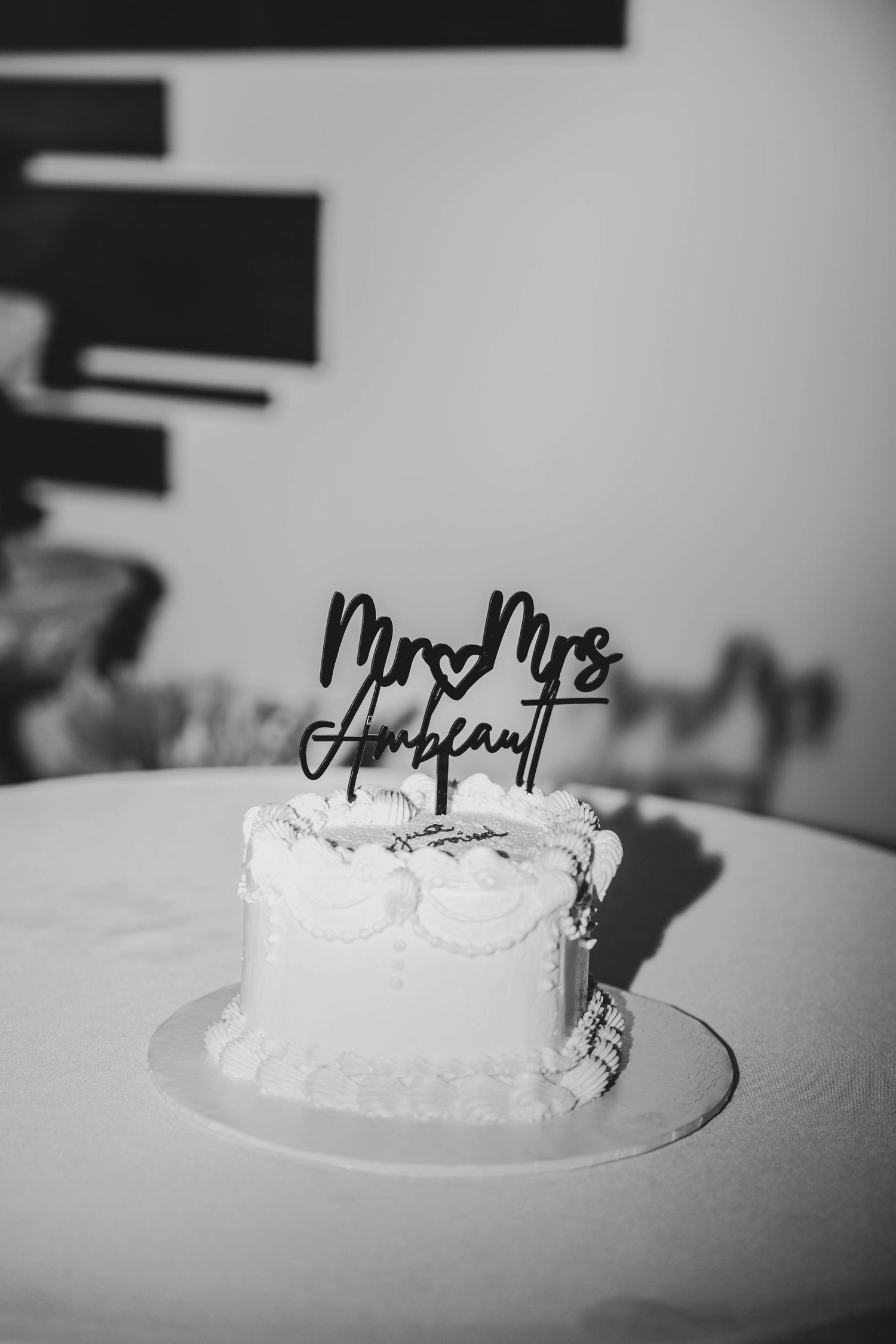 White wedding cake with Mr and Mrs topper photographed in black and white.