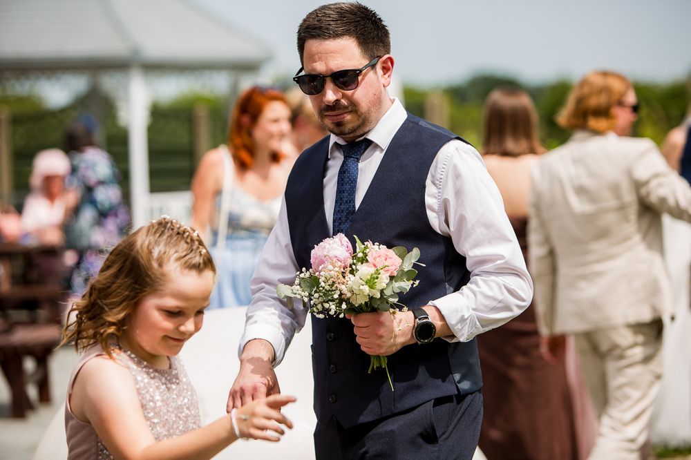 Wedding celebration with guests in formal attire enjoying outdoor reception.
