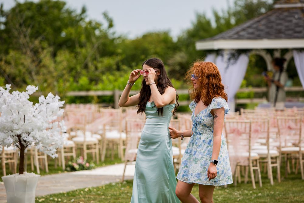 Outdoor wedding venue with garden setting and white chairs set up for ceremony.