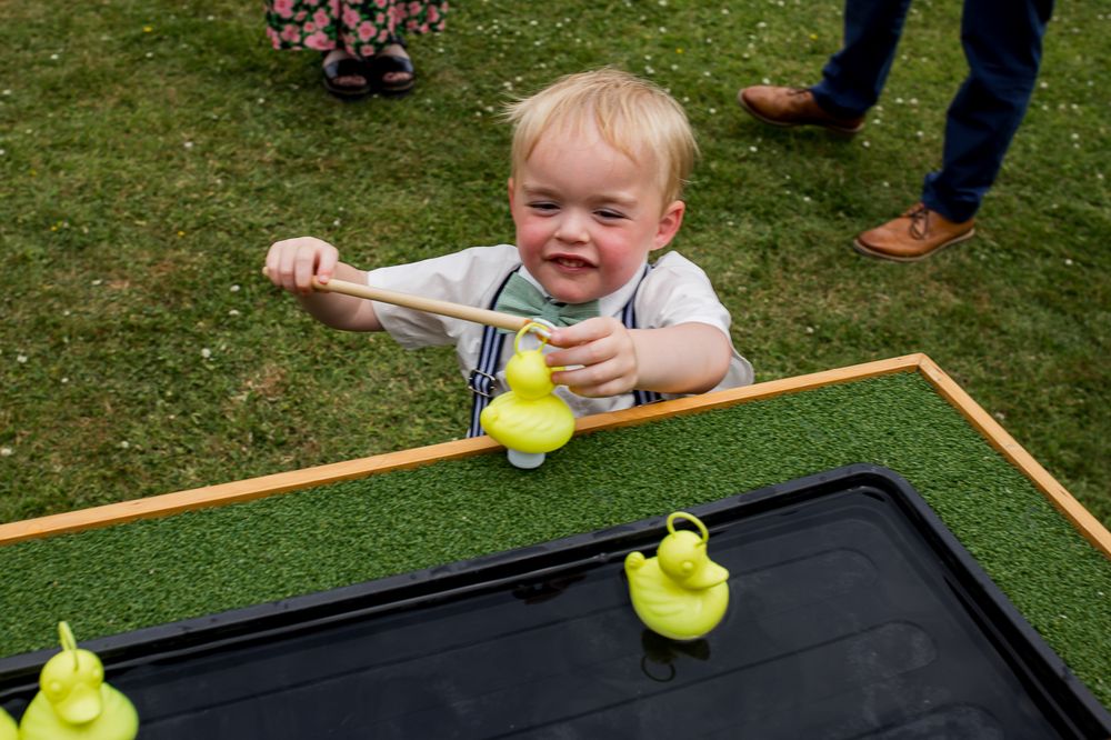 Close-up view of a wooden ball rolling game being played on grass during an outdoor event.