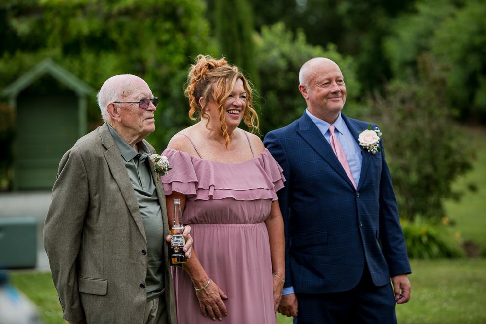 Wedding party members gathered outdoors in formal attire during a summer celebration.