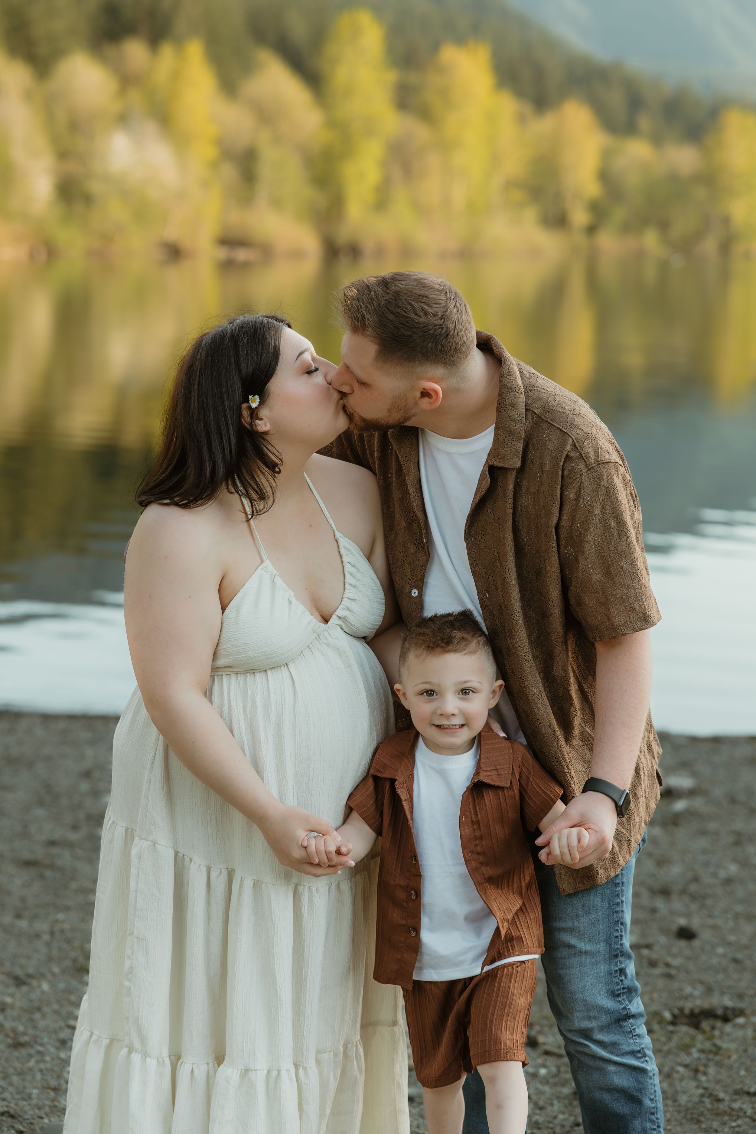A couple shares tender moments by a lakeside during an autumn photo session.