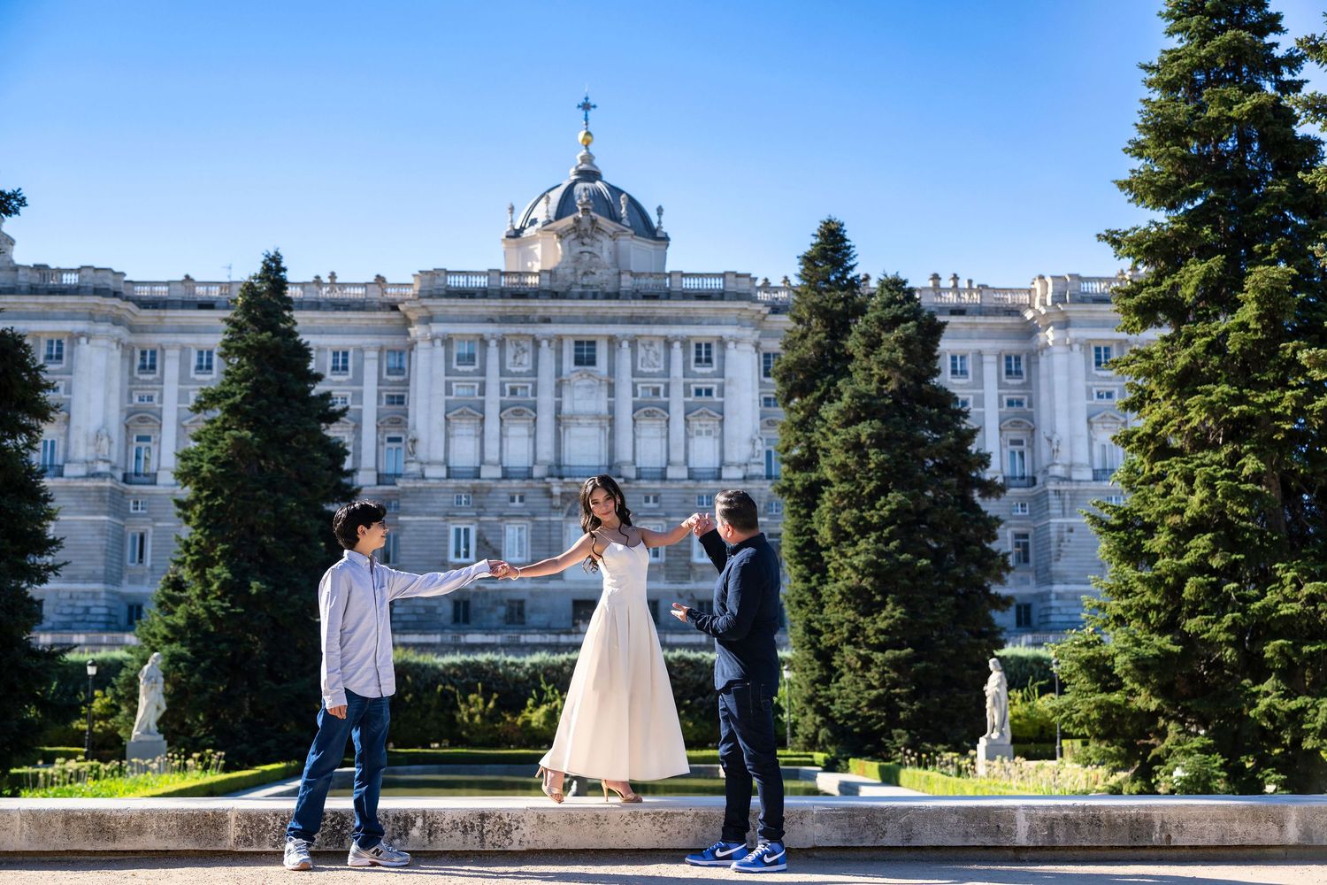A couple shares a romantic moment during their wedding photoshoot in front of the Royal Palace of Madrid.