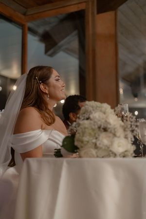 Elegant reception setting with white floral centerpieces and soft lighting.