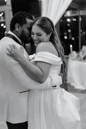 Black and white candid dance moment at wedding reception with elegant decor.