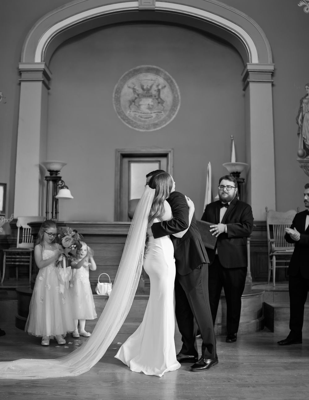 Wedding ceremony candid moments captured in black and white in an elegant venue.