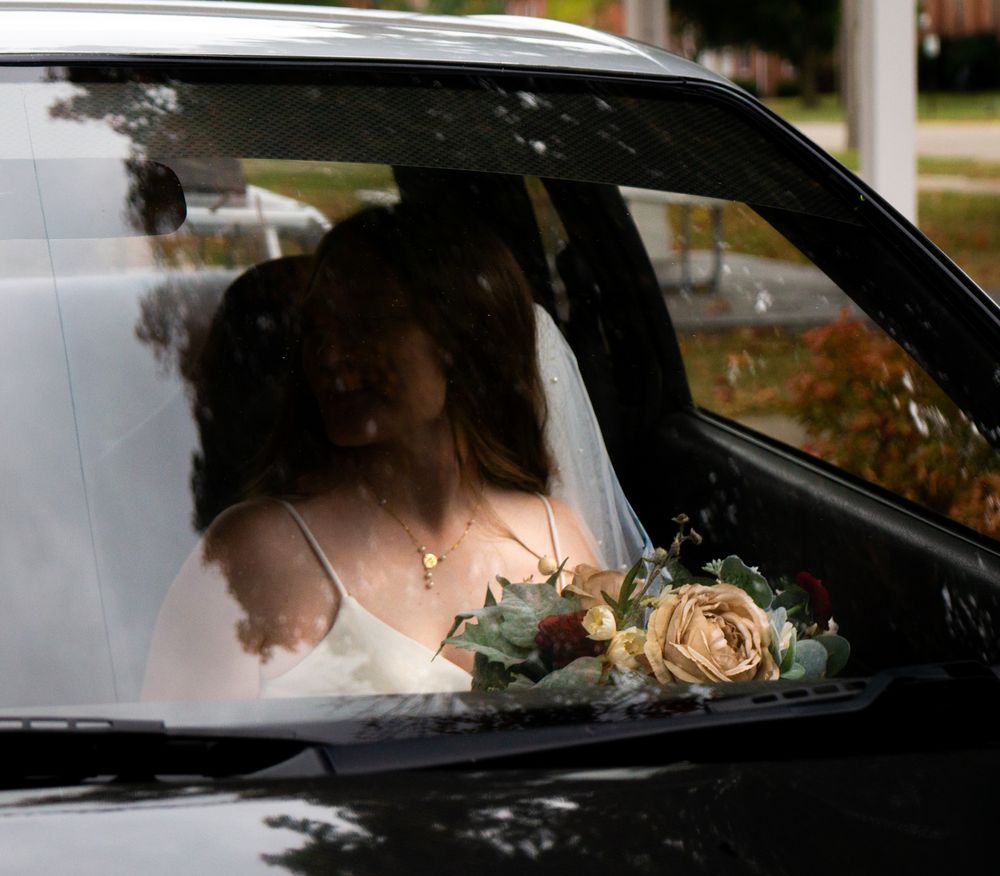 A romantic car window scene with delicate roses decorating the vehicle.