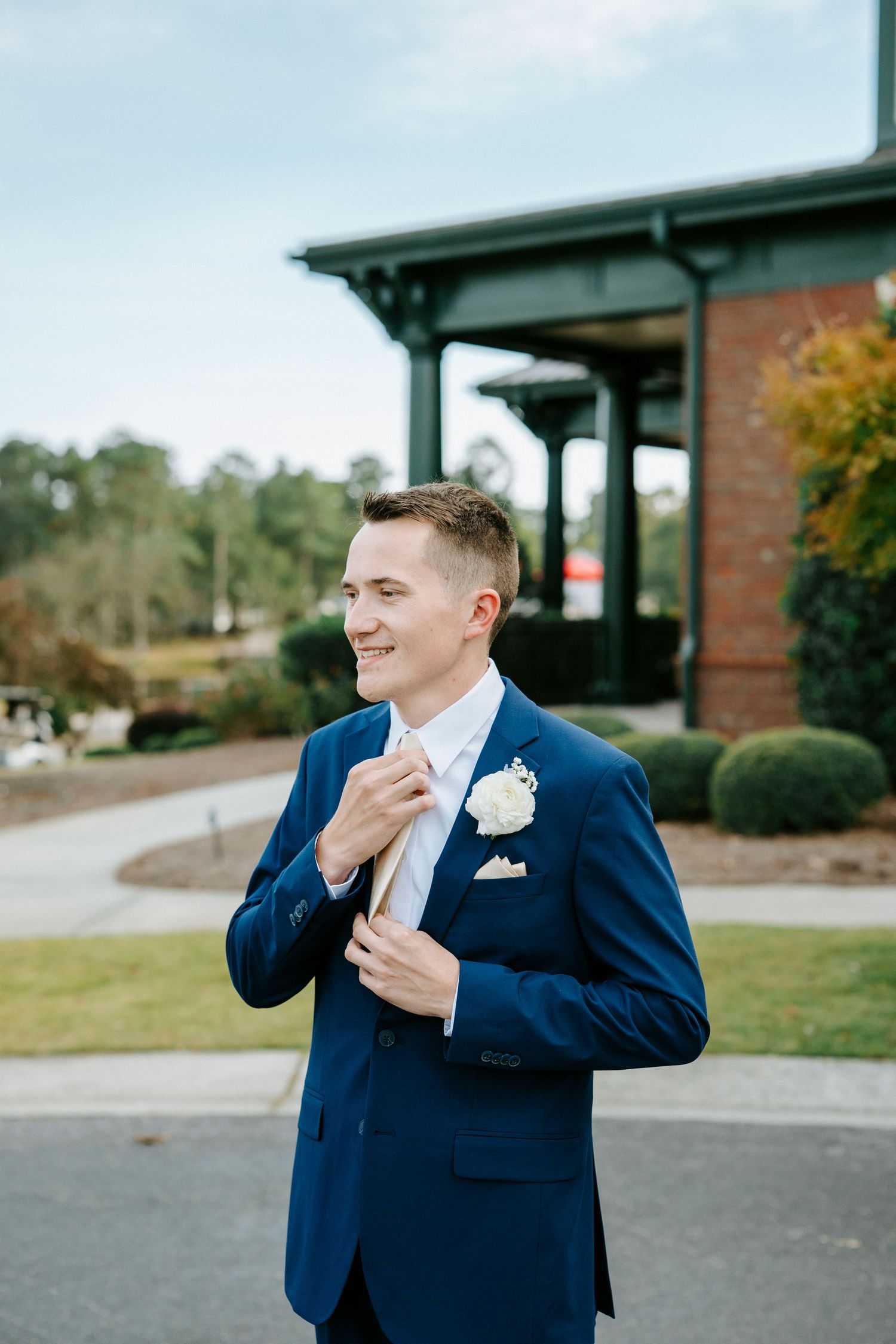 A person in a navy blue suit and white boutonniere reacts emotionally in a series of candid outdoor photos.
