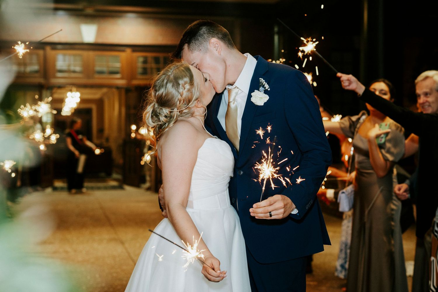 Couple dancing together during an elegant evening wedding reception in a warmly lit ballroom.