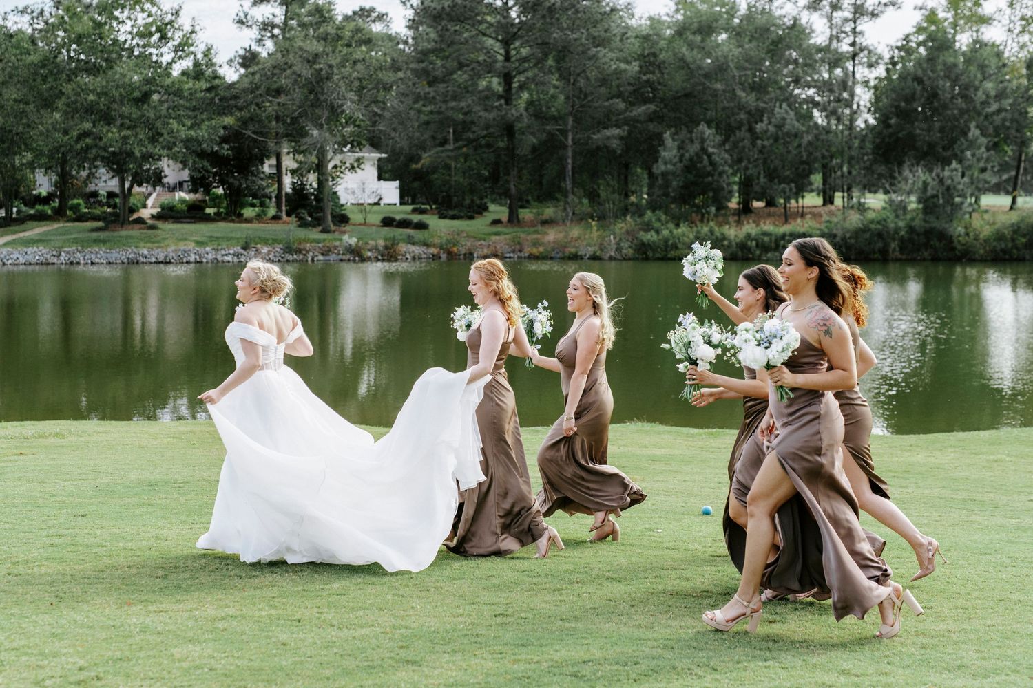 Wedding party relaxing on lush green grass during an outdoor photo session.