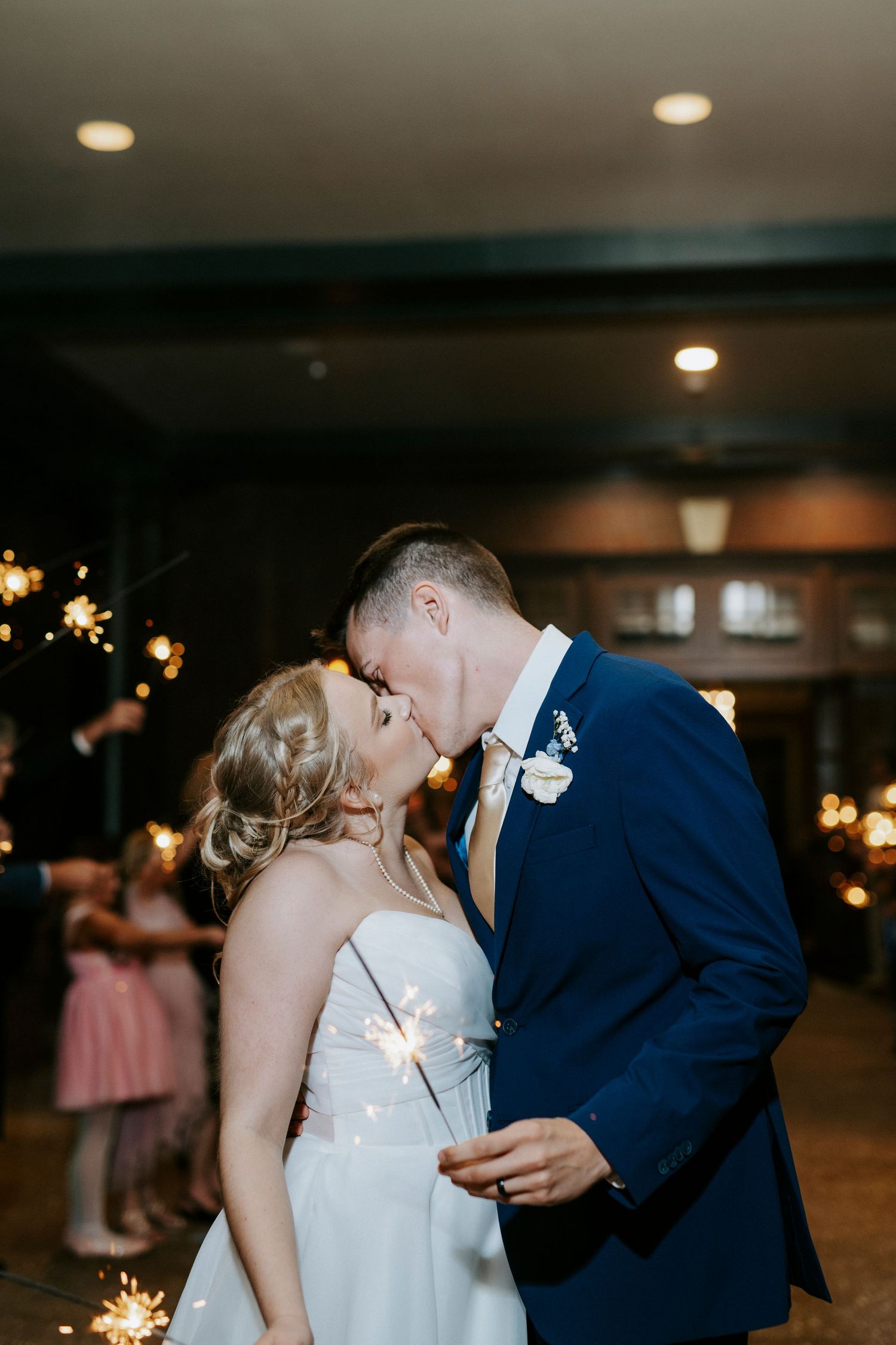 Romantic first dance moment between newlyweds in dimly lit reception venue.