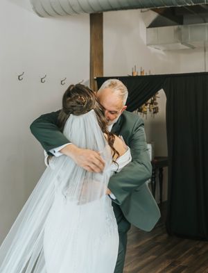 A tender moment is shared between two people during what appears to be a wedding celebration.