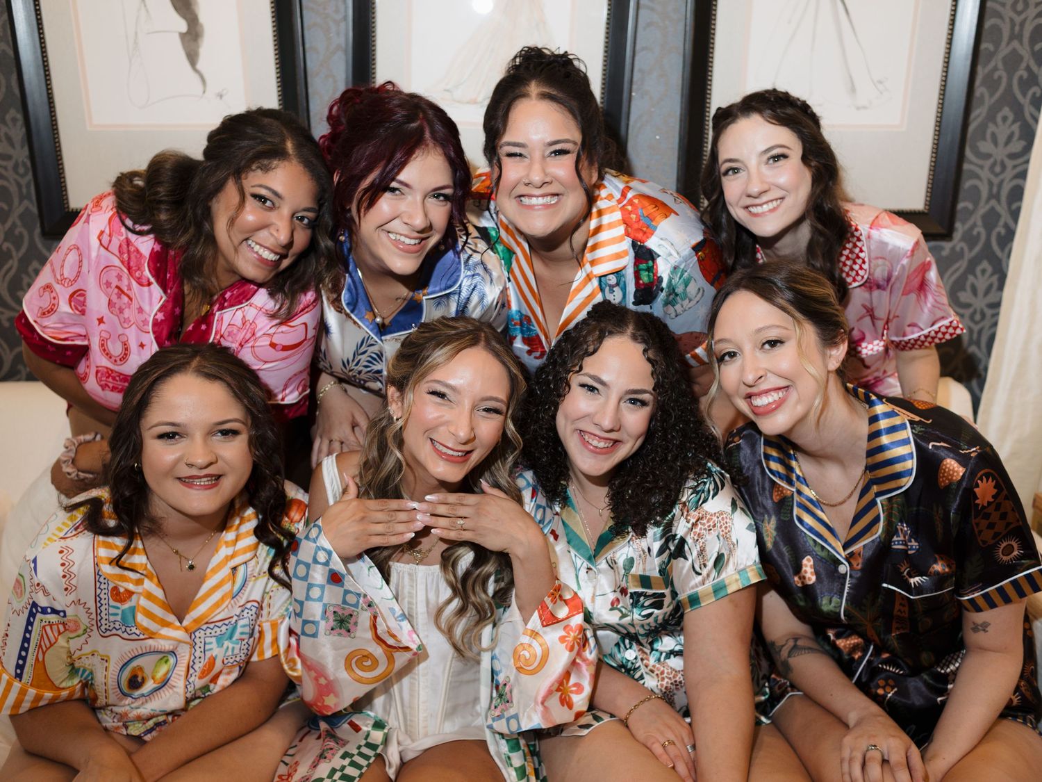 Large group of bridesmaids in colorful dresses posing together at a wedding celebration.