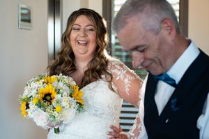 Wedding ceremony participants share emotional moments while reading from papers outdoors.
