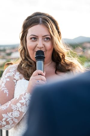 Emotional wedding vow reading during outdoor mountain ceremony with sunflowers.