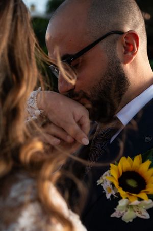 Artistic wedding portrait with sunflowers in golden evening light.