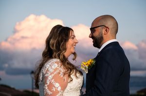 Sunset wedding portraits by the ocean with mountain views.