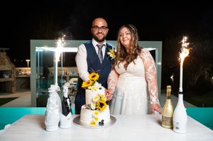 Wedding celebration at night with sunflowers and candles on turquoise table.