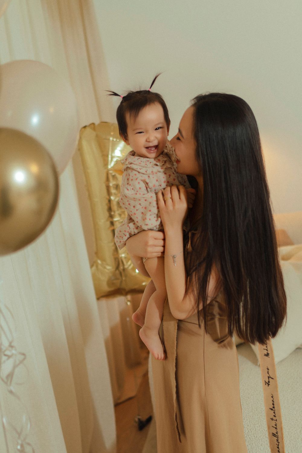 A heartwarming moment at a celebration with gold balloons and decorative accents in warm lighting.