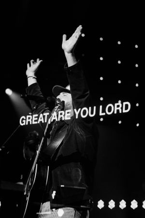 Black and white worship concert image with 'Great Are You Lord' text and raised hands.