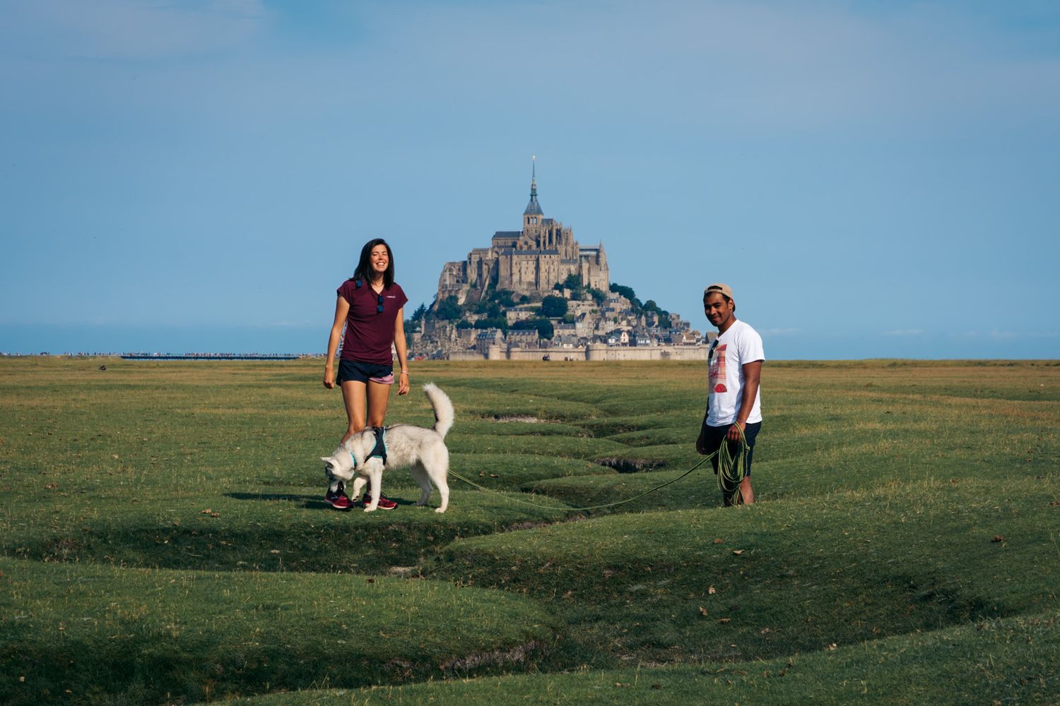 Mont-Saint-Michel en arrière plan avec des voyageurs en premier plan dans les prés salé. Département de la Manche en Normandie