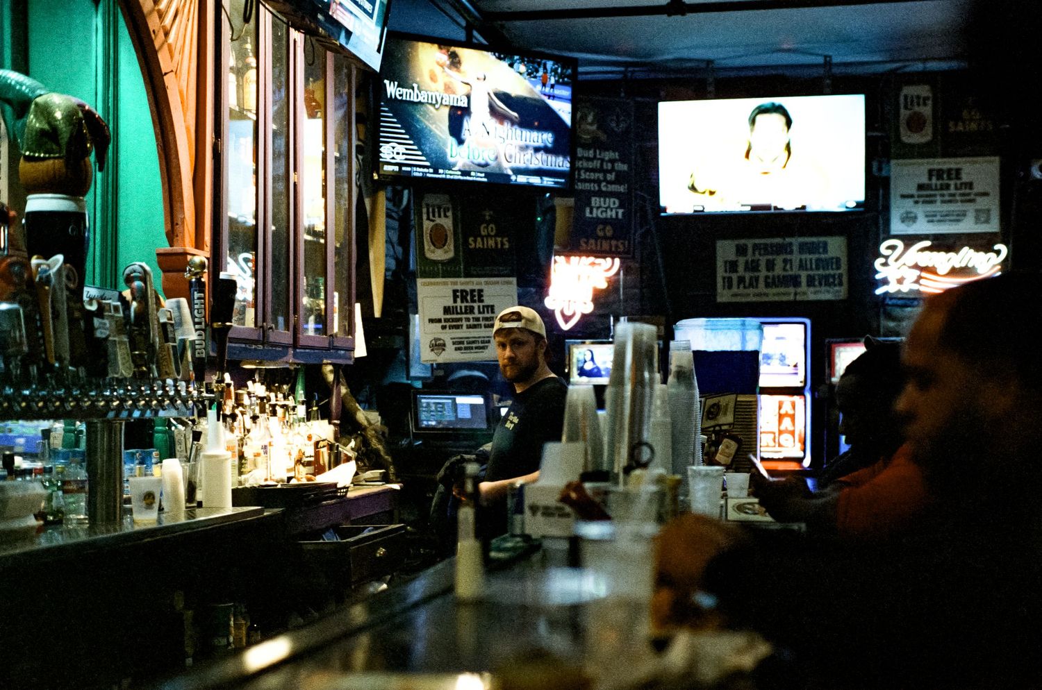 Interior of a sports bar with televisions and rows of liquor bottles behind the counter.