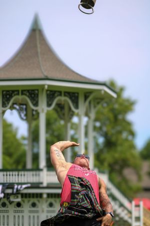 Figure in pink tank top demonstrates athletic movement sequence on grassy field with gazebo backdrop.