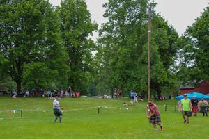 Panoramic view of highland games field showing caber toss competition and spectator areas.