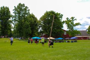 Panoramic view of Highland Games venue with scattered tents and trees in the background.