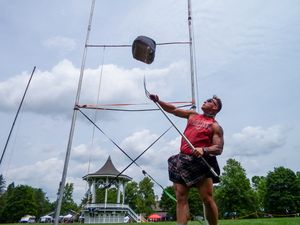 Competitor in traditional kilt attempts weight over bar throw at highland games competition.