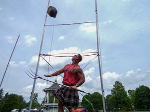 Athlete demonstrates hammer throwing form at outdoor Highland Games event.