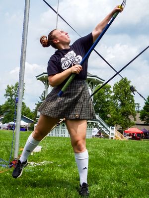 Athlete in traditional kilt executes powerful hammer throw during Highland Games competition.