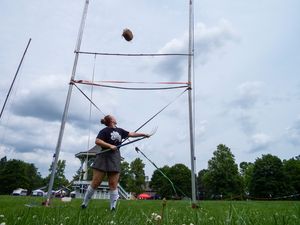 Time-lapse sequence showing a weight throw competition at Highland Games with vertical poles.
