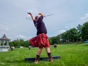 An athlete releases a heavy weight during a Highland Games throwing competition.