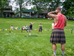 Highland Games participant watches fellow competitors while wearing traditional Scottish kilt.