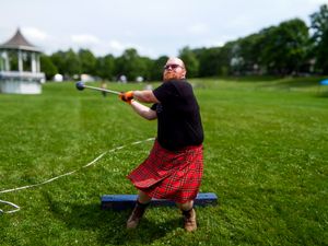 A competitor in traditional Scottish attire throws weights during Highland Games competition.