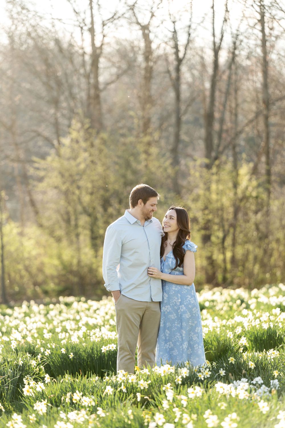 Couple sharing a tender moment together in a glowing spring daffodil field.