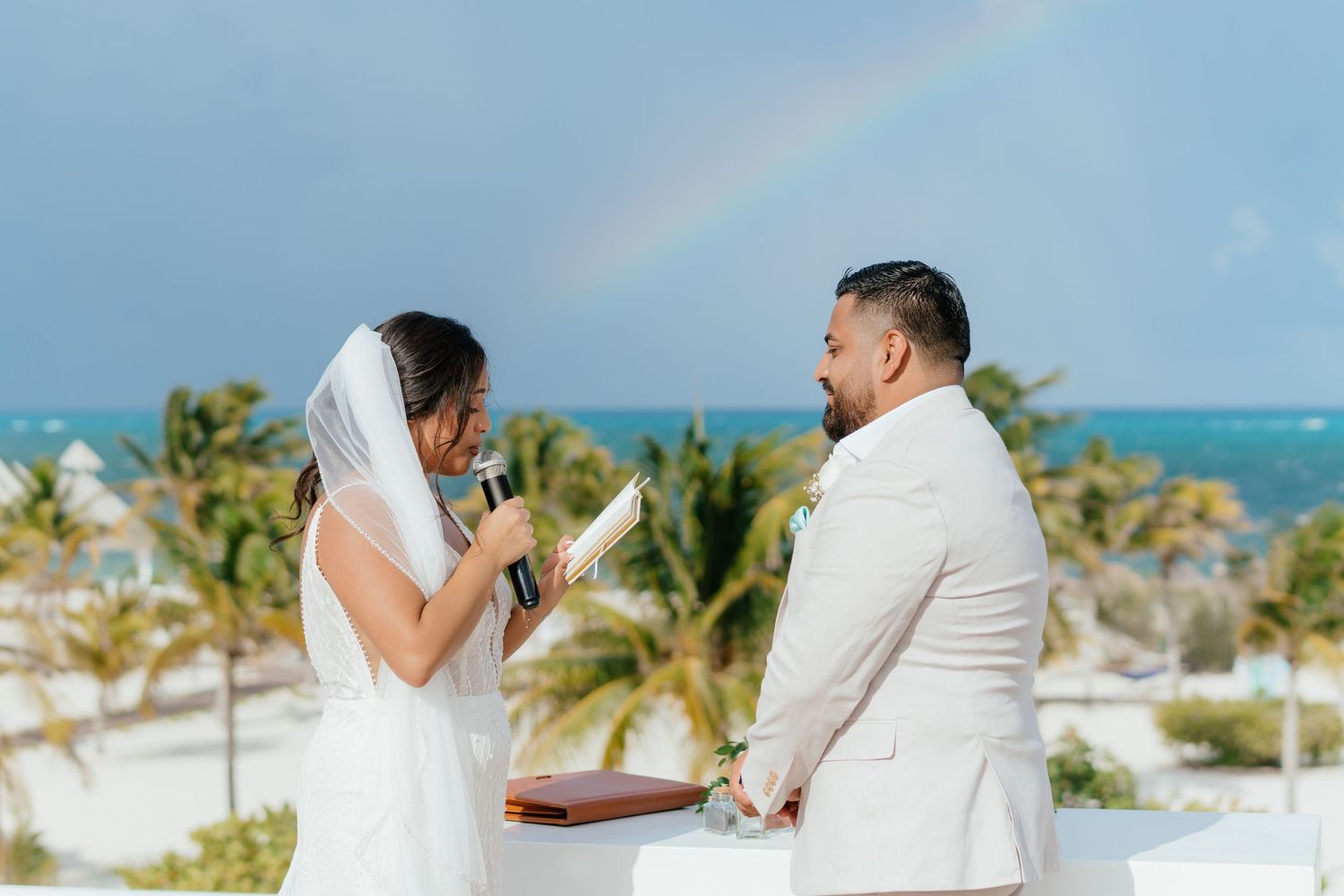 Couple reading wedding vows by the ocean at Majestic Elegance Costa Mujeres in the Riviera Maya.