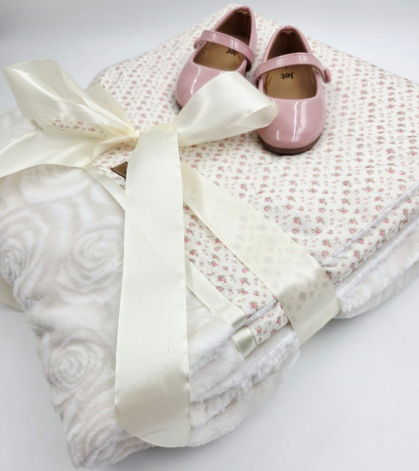 Baby quilt and pillow set with cute giraffe and bear pattern in neutral tones, displayed on a brown waffle blanket.