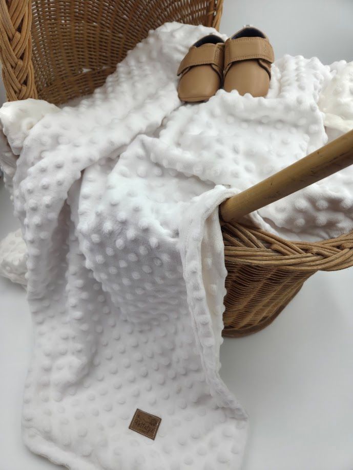 Stack of soft minky dot baby blankets in mint and beige, tied with satin ribbons, perfect for newborns.