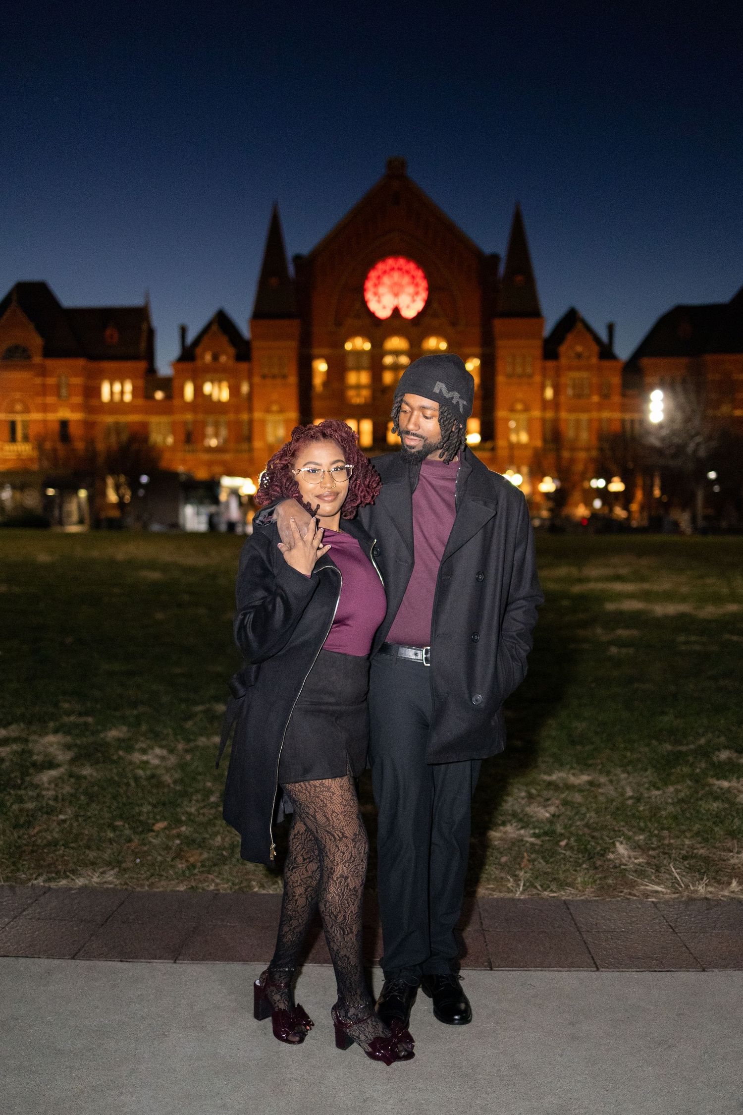Smiling couple posing at night in front of Music Hall, Cincinnati Ohio.