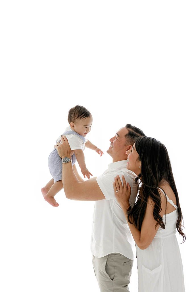 Bright white photography studio near French Valley California - smiling family with baby boy.