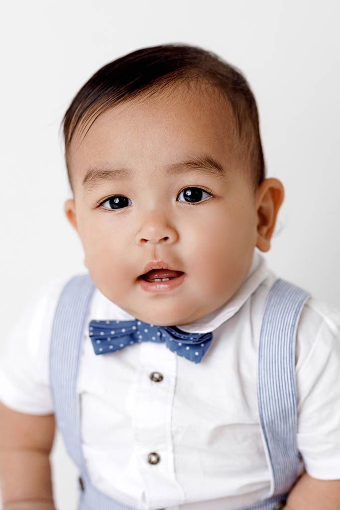 French Valley baby photographer close-up portrait of an adorable baby boy against a white background.