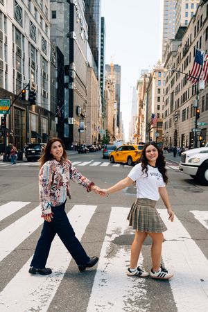 A sequence of playful poses on a New York City crosswalk with yellow taxis and tall buildings in the background.