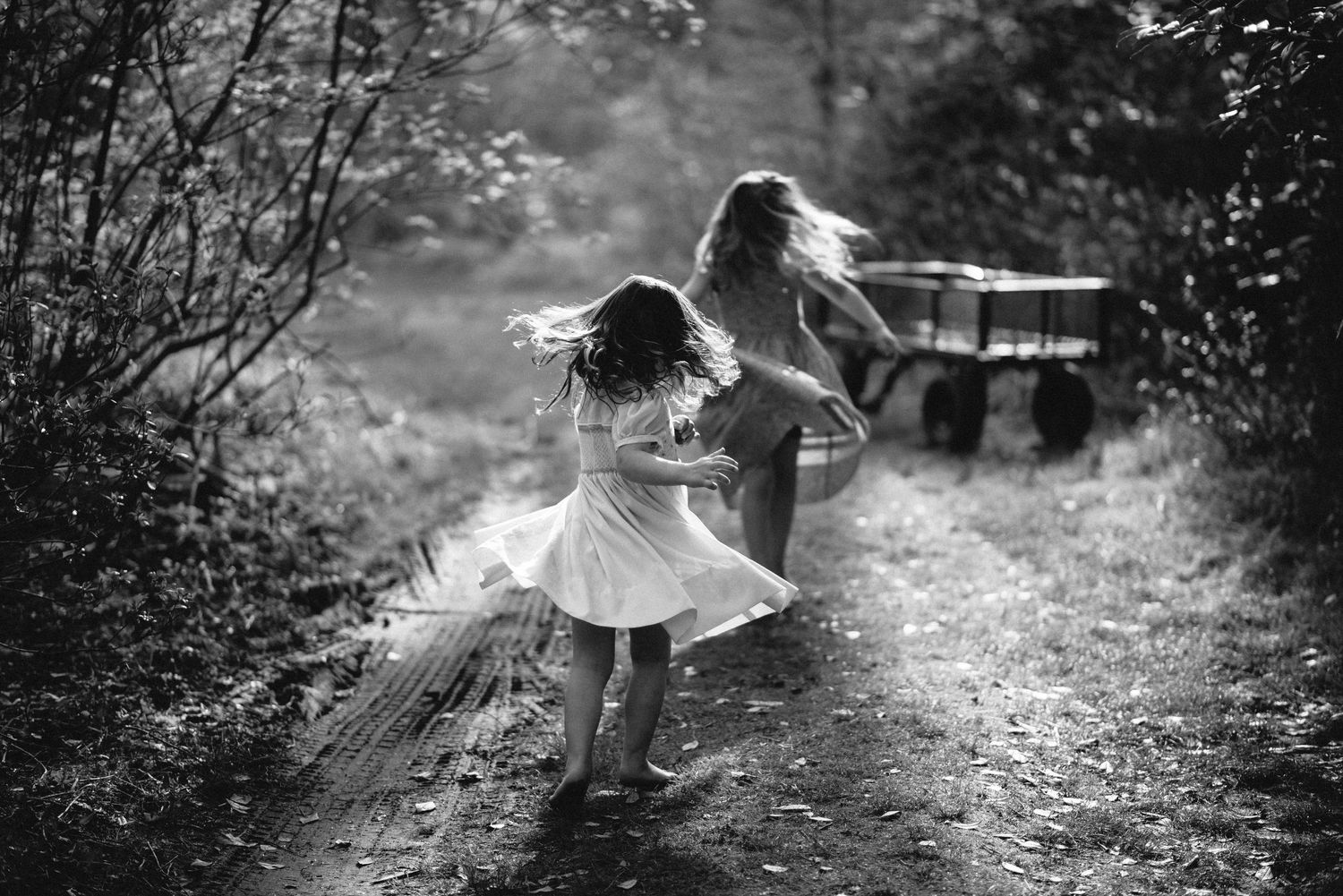 Black and white family photograph of girls spinning in sunlight at Kinney Azalea Gardens in Rhode Island