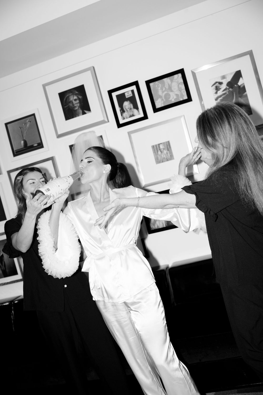 Black and white photo of bridesmaids getting ready, sharing laughs and excitement before the ceremony.