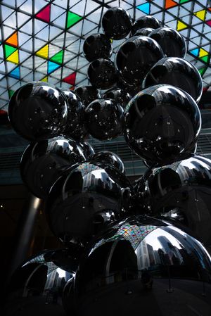 Shiny metallic spheres reflecting light under colorful triangular bunting decorations.