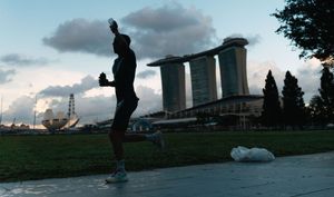 Silhouettes of people walking along a waterfront path at dusk.