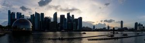 Panoramic cityscape view with dramatic clouds during golden hour.
