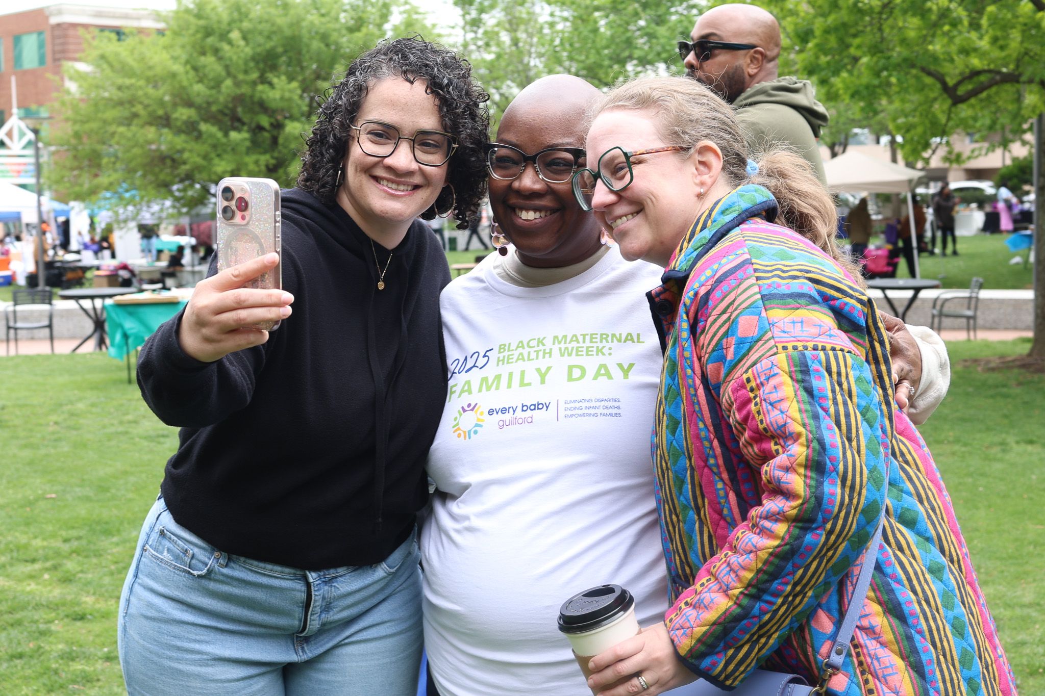 Group of supporters take a selfie together at an outdoor community event.